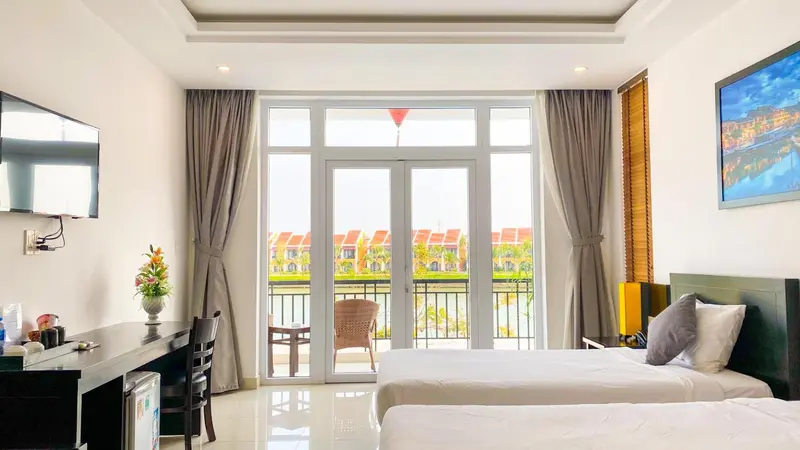 Une chambre lumineuse avec un grand lit et un accès à un balcon.
