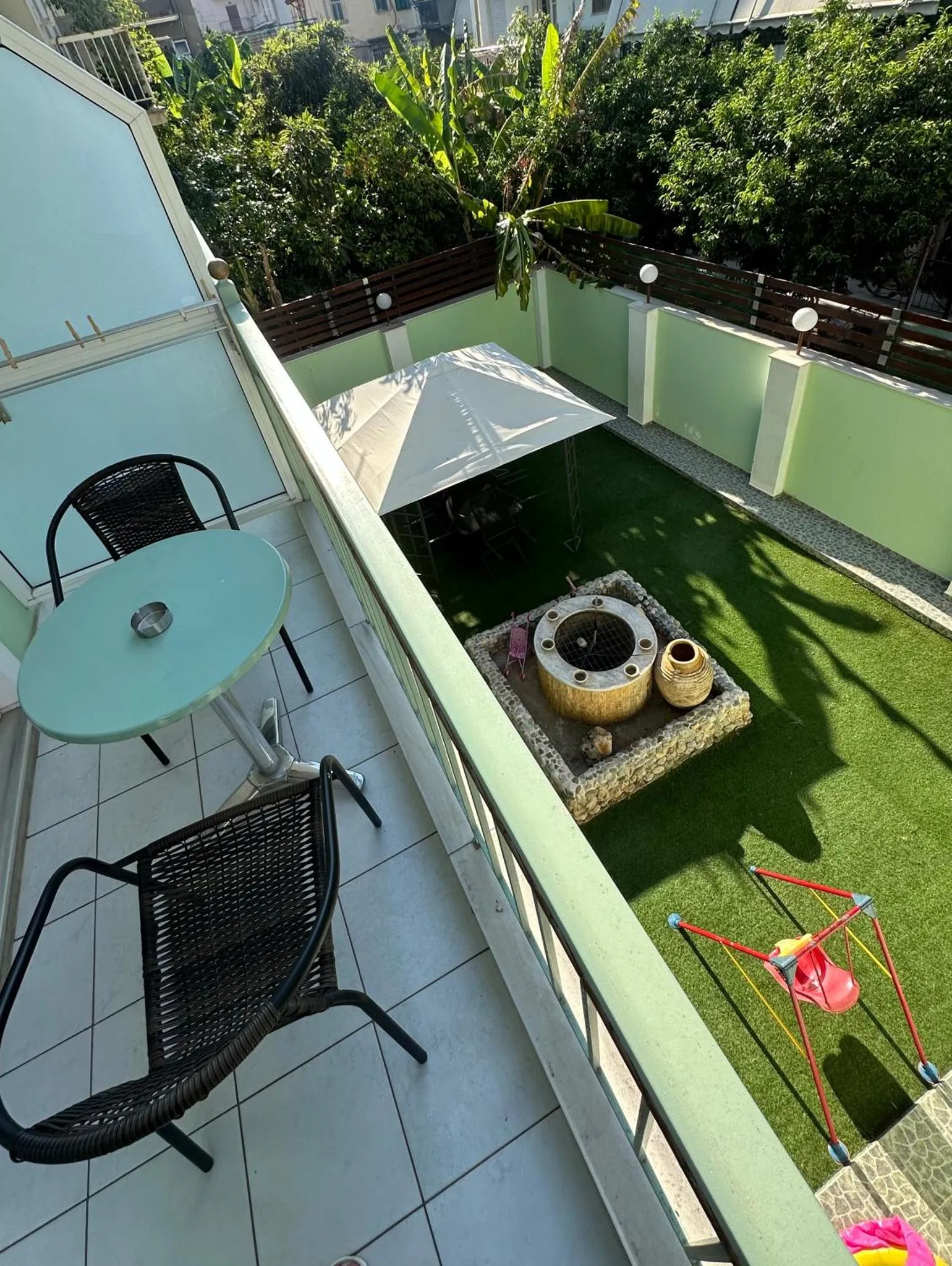 Terrasse avec mobilier de jardin et gazon artificiel.