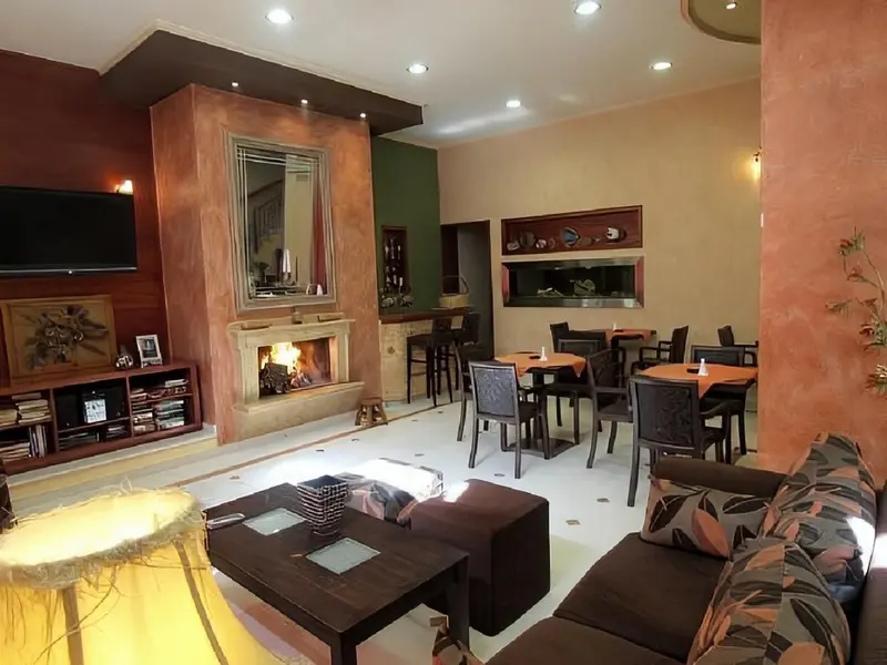 Un espace de séjour lumineux avec canapés, tables basses et un coin repas.