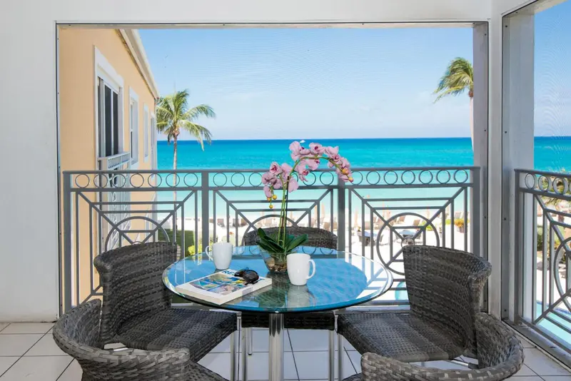 Une table ronde avec des chaises sur un balcon donnant sur la mer.