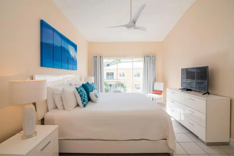 Une chambre lumineuse avec un grand lit et une vue sur l'extérieur.