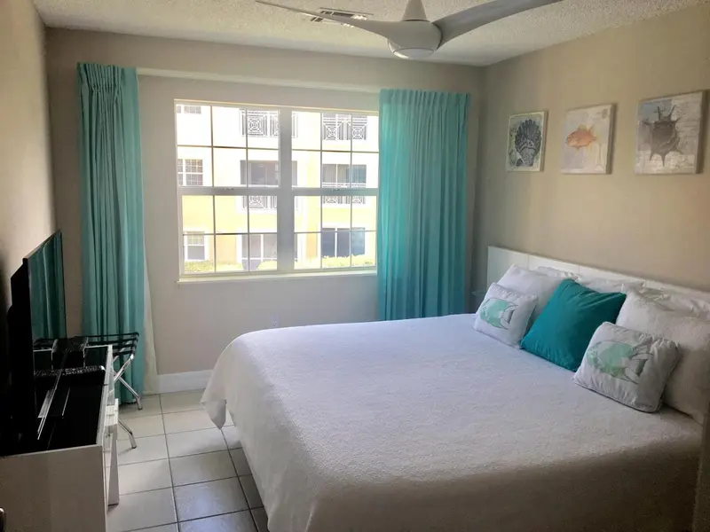 Une chambre lumineuse avec un grand lit recouvert de linge blanc.