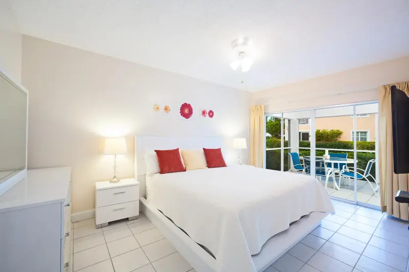 Une chambre lumineuse avec un grand lit et un accès à une terrasse.
