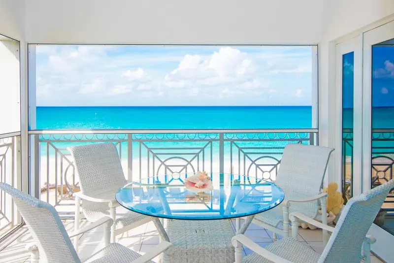 Vue sur l'océan depuis un balcon avec mobilier d'extérieur.