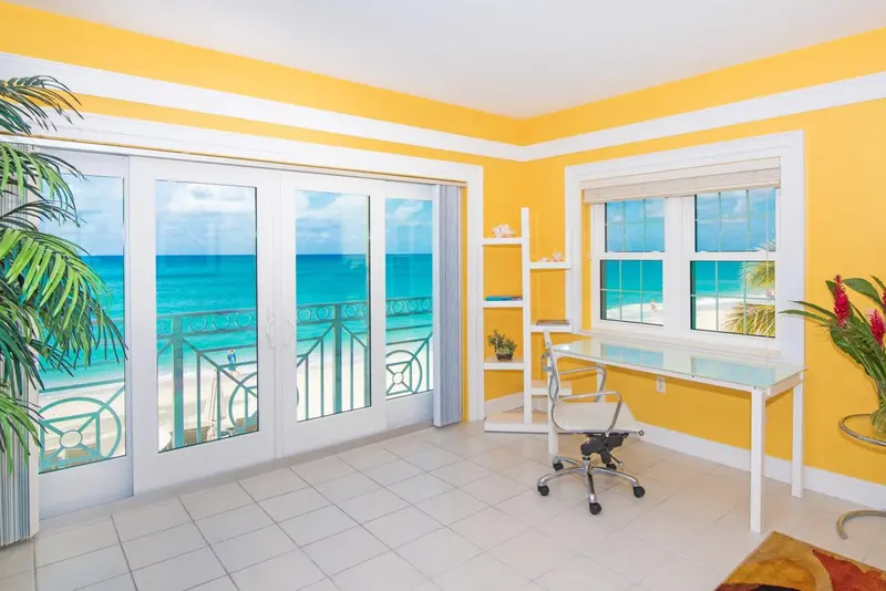 Une pièce lumineuse avec un bureau donnant sur la mer.