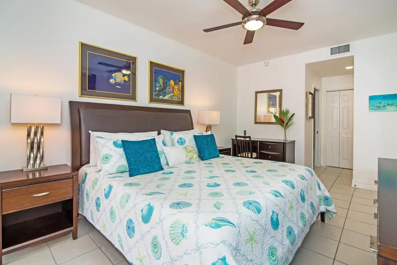 Une chambre lumineuse avec un grand lit décoré de motifs marins.