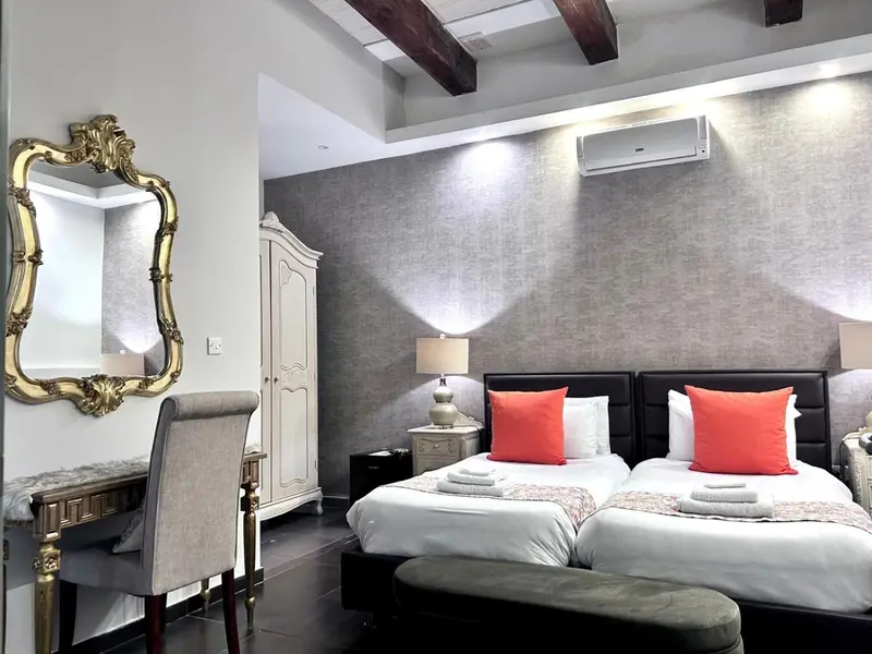 Une chambre avec un grand lit et un miroir doré.