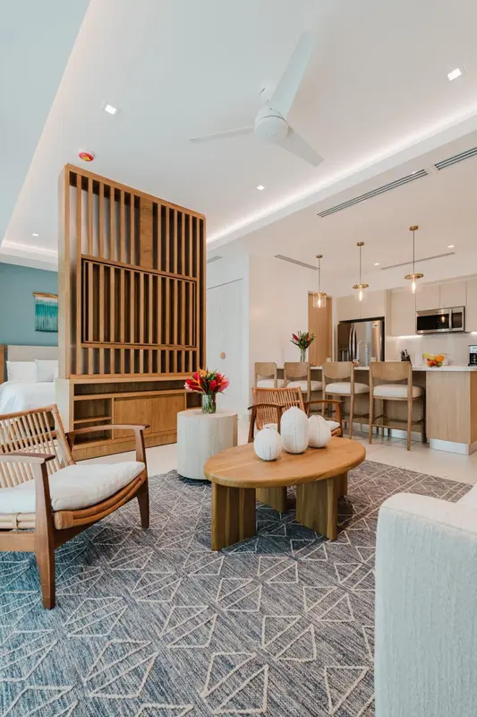 Espace de vie lumineux avec canapés, table basse et cuisine ouverte.