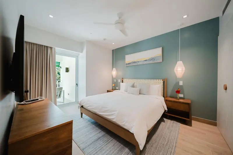 Une chambre lumineuse avec un grand lit et un accès à une terrasse.