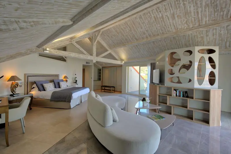 Une chambre lumineuse avec un lit king-size et un espace salon.