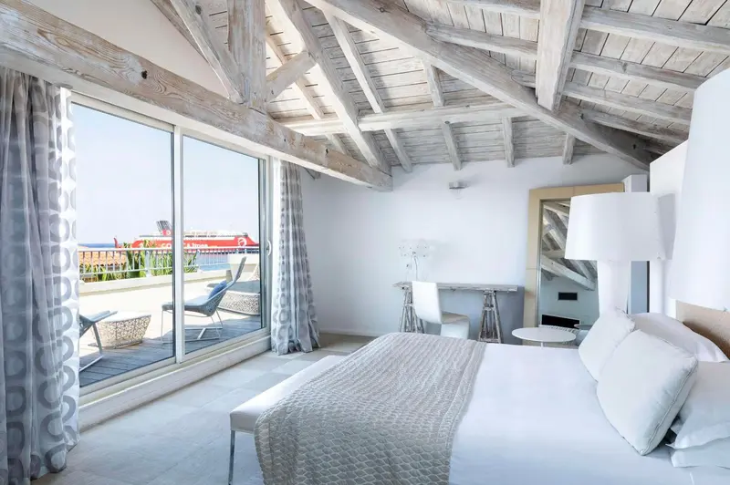 Une chambre lumineuse avec un lit et un accès à une terrasse.