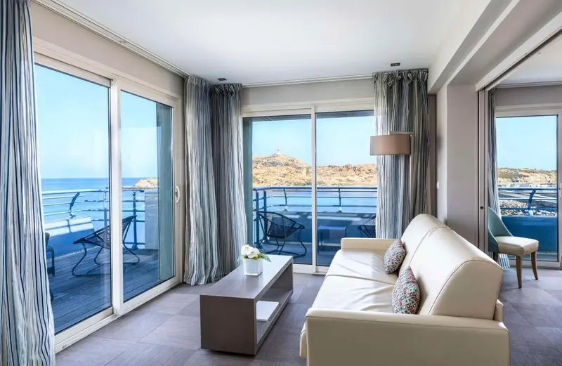 Un salon lumineux s'ouvre sur une terrasse avec vue sur la mer.