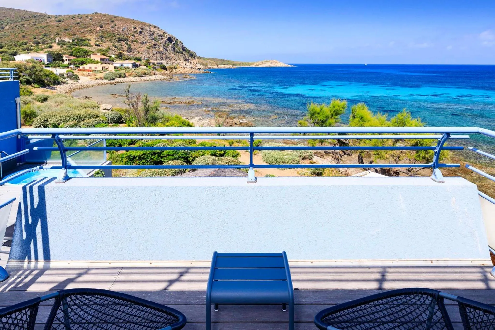 Terrasse avec vue sur la mer et la côte rocheuse.