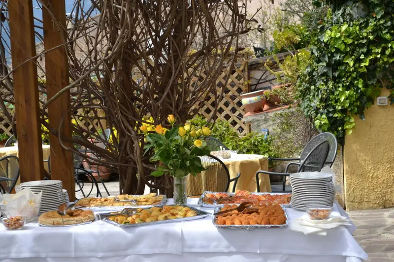Une table garnie de plats variés est présentée en extérieur.