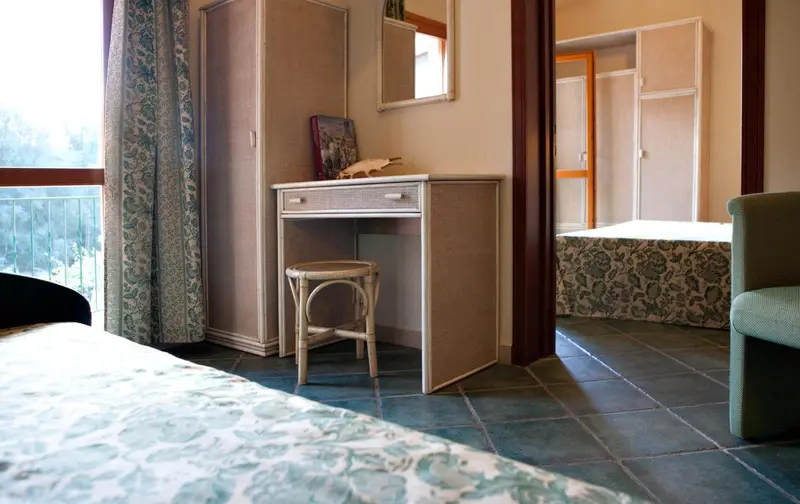 Une coiffeuse en bois clair se trouve dans une chambre d'hôtel.