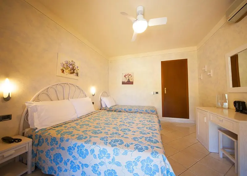 Une chambre lumineuse avec un lit double et une décoration florale.