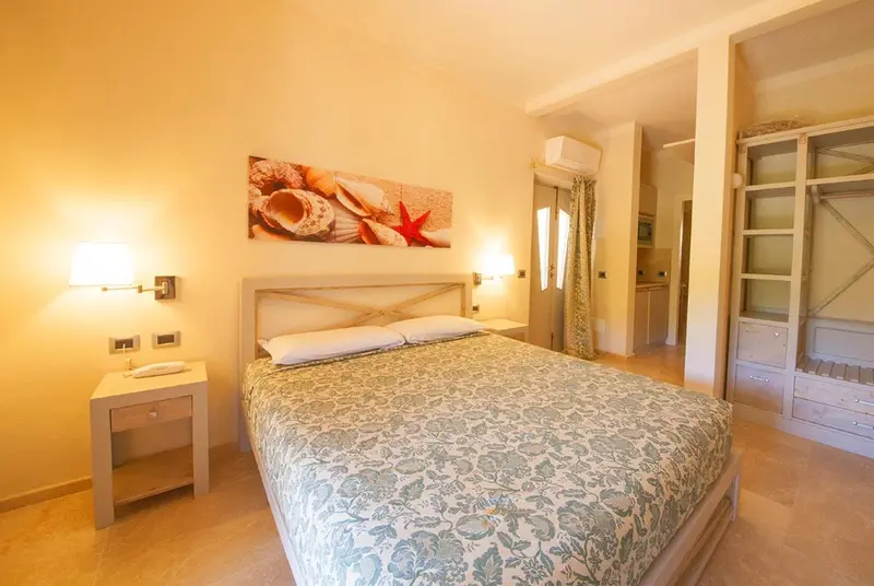 Une chambre lumineuse avec un grand lit recouvert d'une courtepointe à motifs.