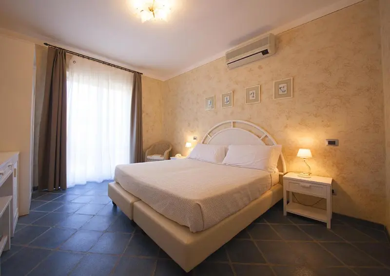 Une chambre lumineuse avec un grand lit et des rideaux.