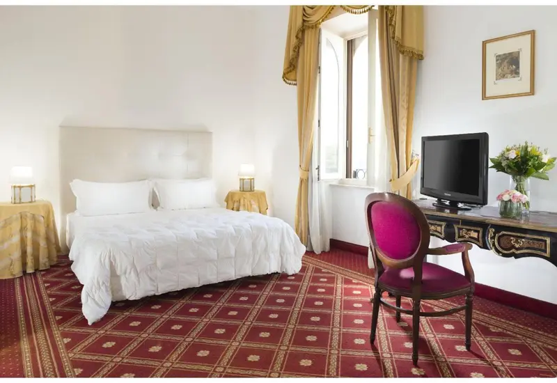 Chambre lumineuse avec un lit double et un bureau.