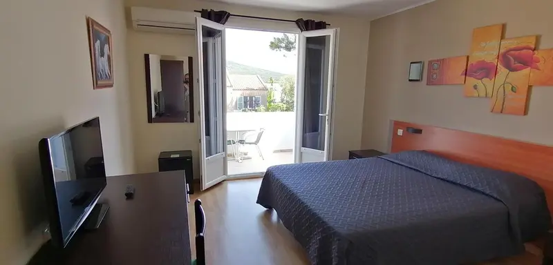 Une chambre avec un lit double donnant sur une terrasse.