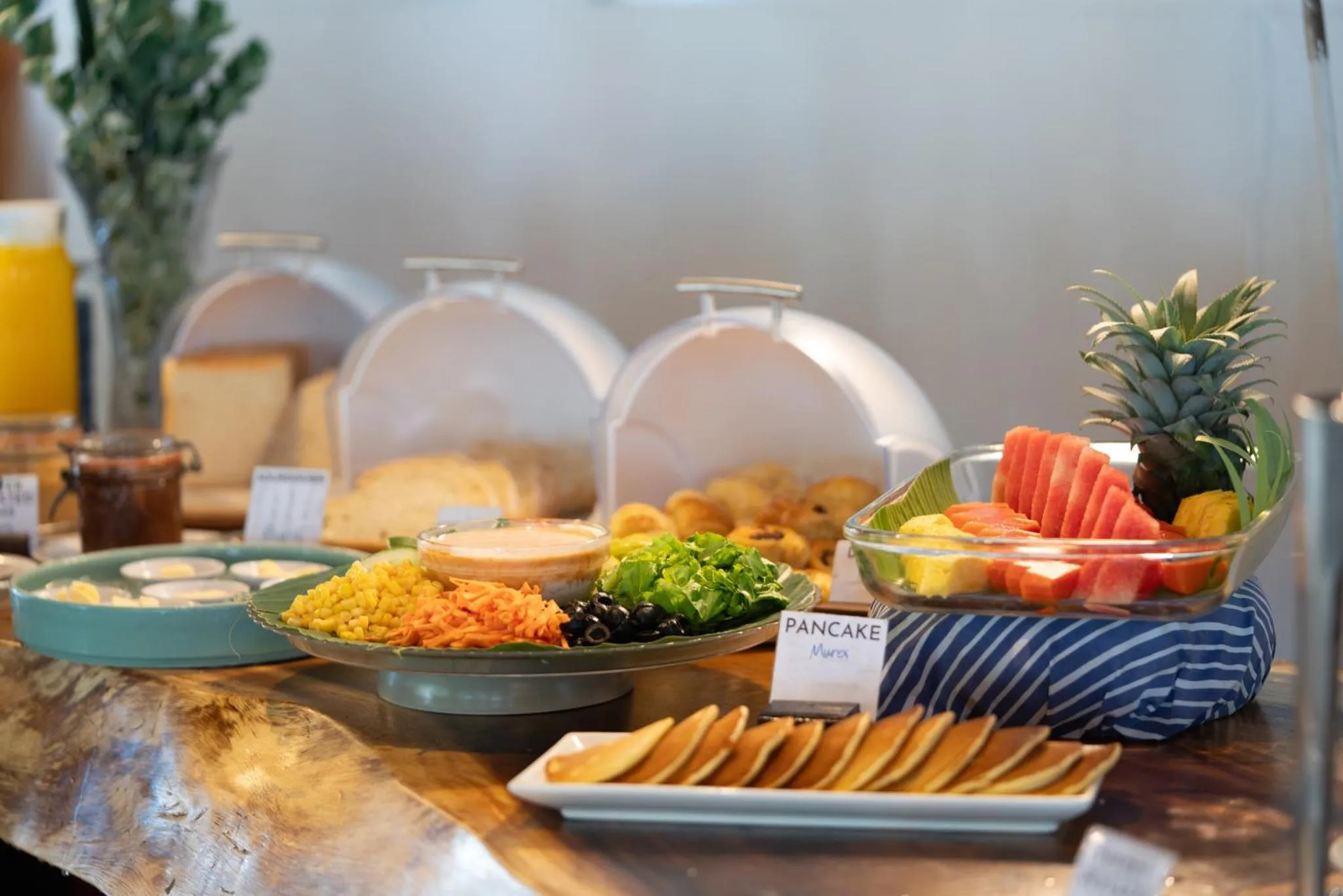 Un buffet propose des fruits frais, des salades et des pâtisseries.