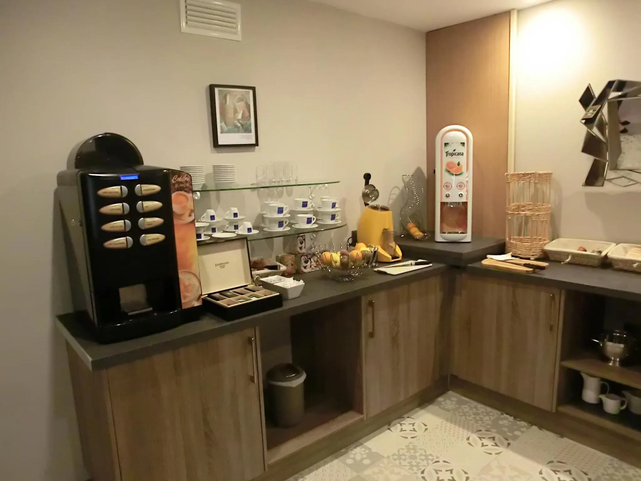 Un comptoir de boissons et une sélection de tasses et de pâtisseries sont disposés sur un meuble bas.