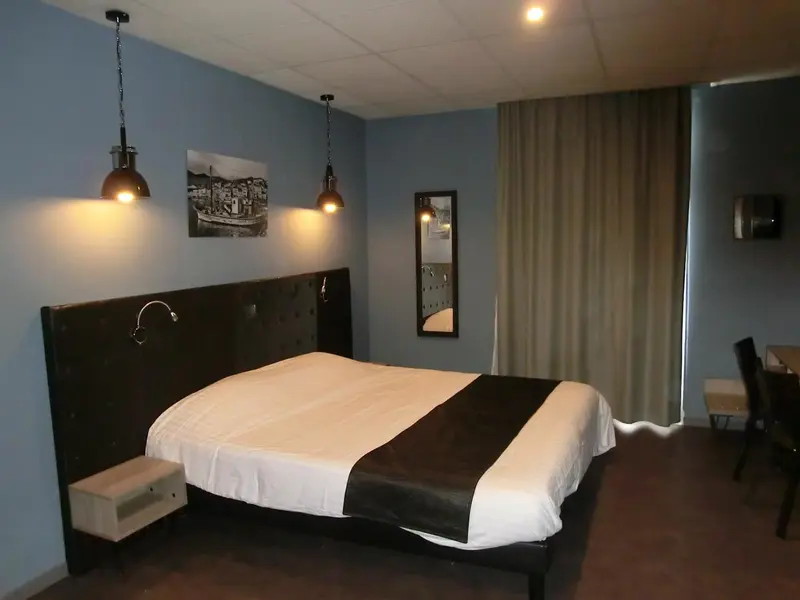 Une chambre avec un grand lit recouvert d'une courtepointe blanche et noire.