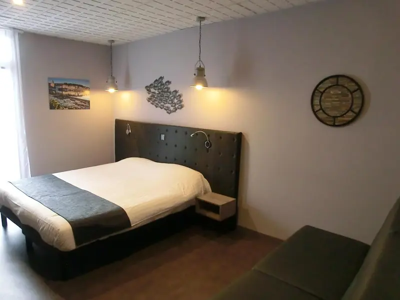 Une chambre avec un grand lit et une décoration murale.