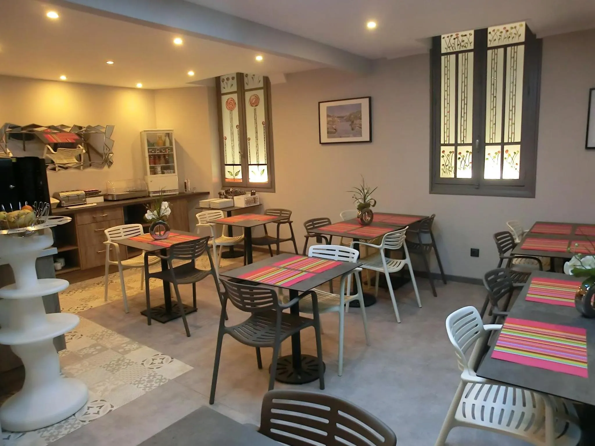 Une salle lumineuse avec des tables et des chaises pour le petit-déjeuner.