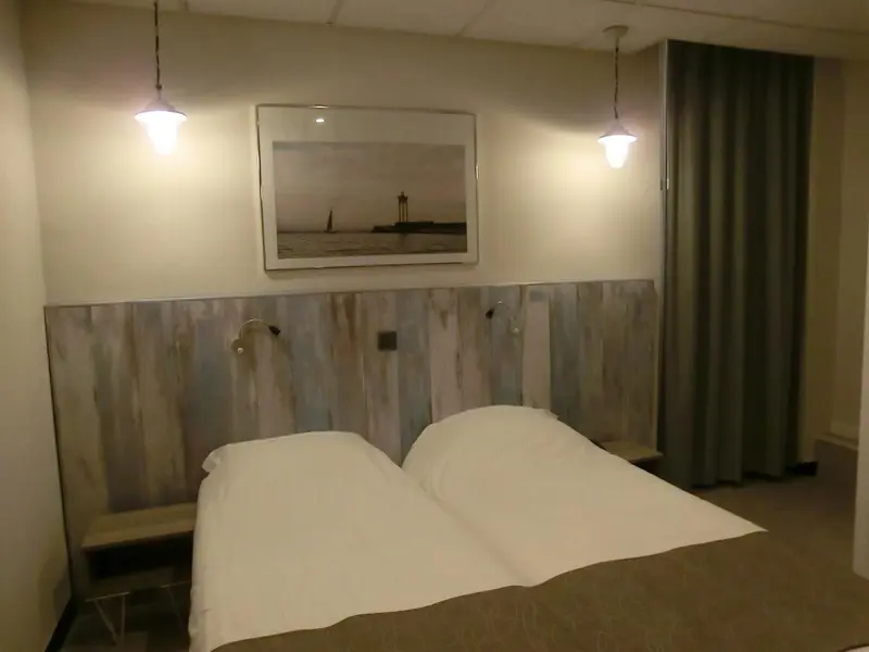Une chambre avec un lit double et une décoration murale.