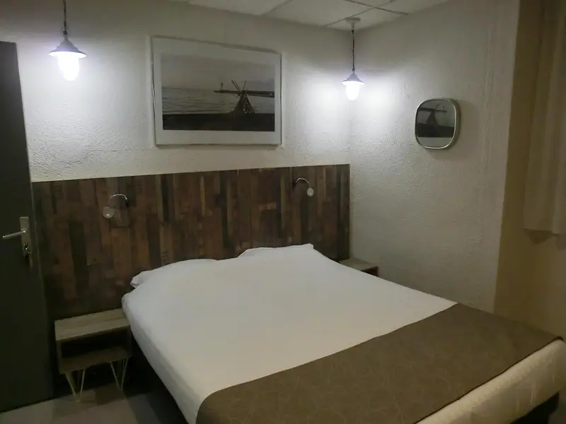 Une chambre lumineuse avec un lit simple et une décoration murale.