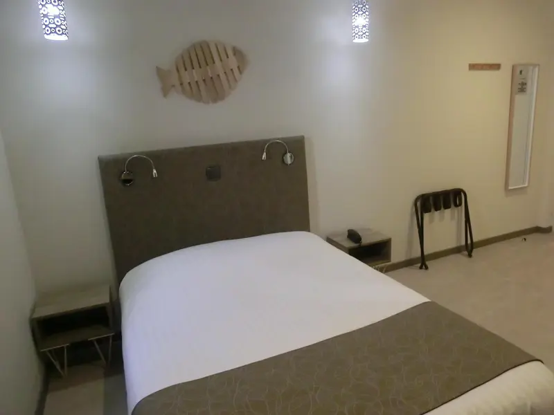 Une chambre avec un grand lit et une décoration murale en forme de poisson.
