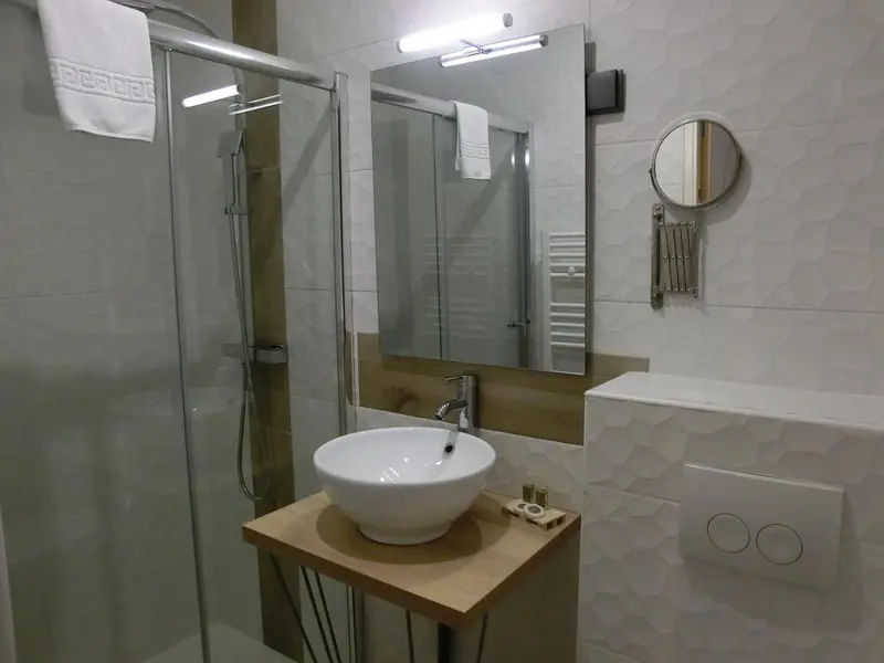 Une salle de bain moderne avec douche à l'italienne et vasque sur meuble.