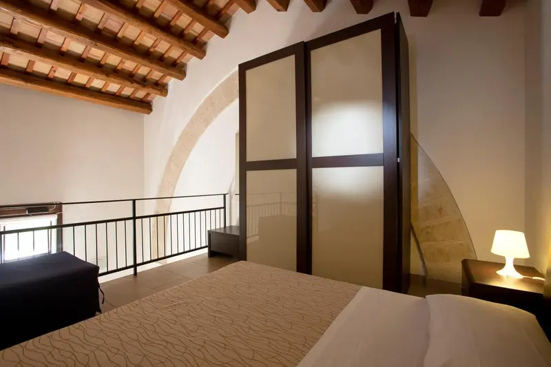 Une chambre lumineuse avec un lit et une armoire intégrée.