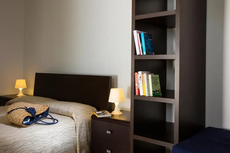 Une chambre lumineuse avec un lit et une bibliothèque.