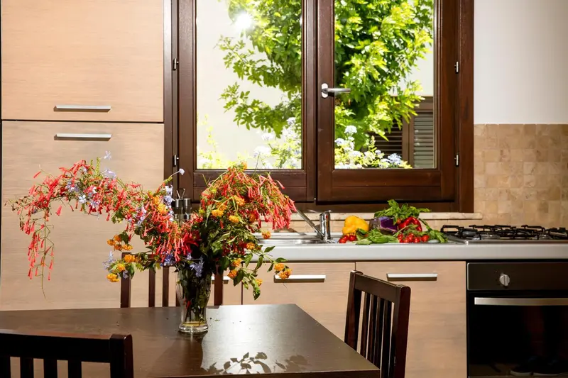 Une cuisine lumineuse avec un bouquet de fleurs sur un plan de travail.