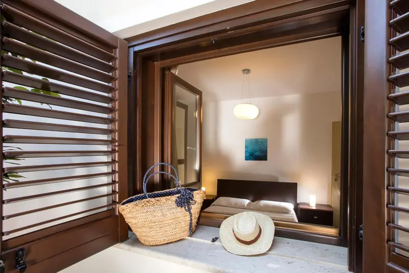 Une chambre avec un lit et un panier en osier sur le seuil.