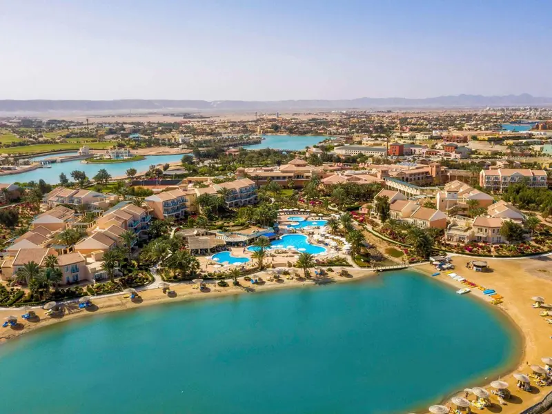 Vue aérienne d'un complexe hôtelier bordant une plage et des canaux.