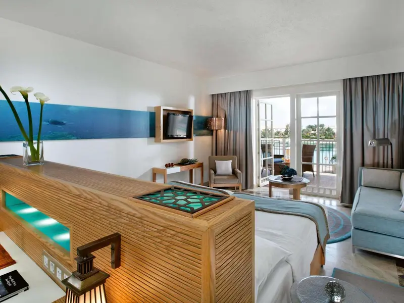 Une chambre lumineuse avec un espace salon et un accès à un balcon.