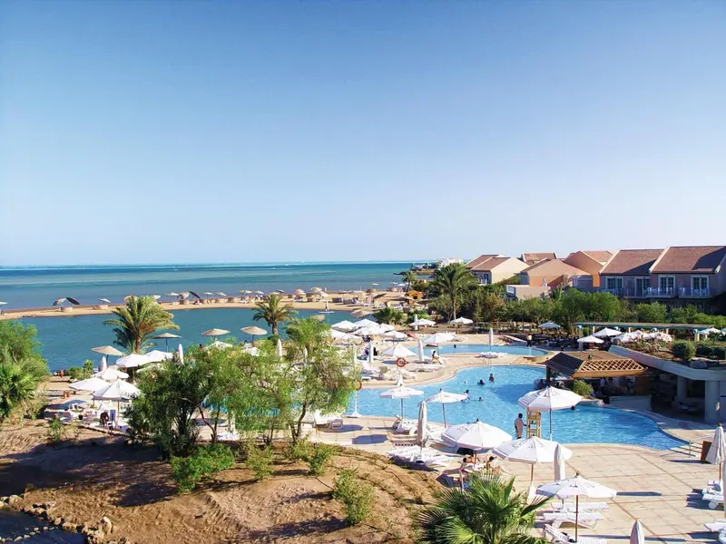 Vue aérienne d'un complexe hôtelier avec piscine et plage.