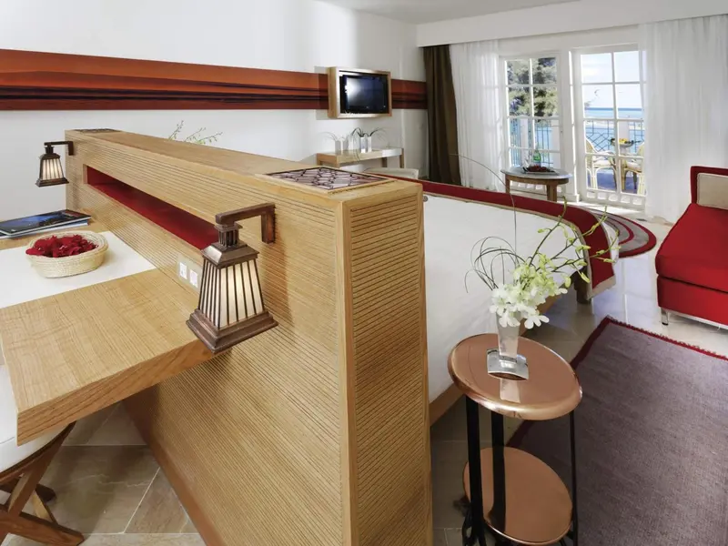 Une chambre avec un espace repas et une vue sur la mer.