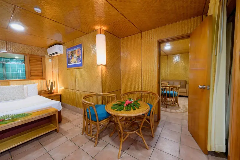 Une chambre lumineuse avec un coin repas et un lit fait.