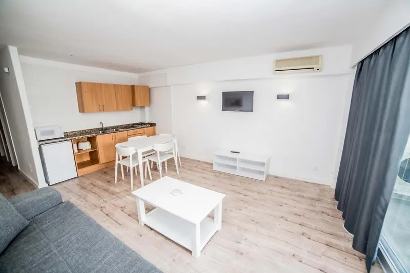 Une pièce lumineuse avec un coin repas et une kitchenette.