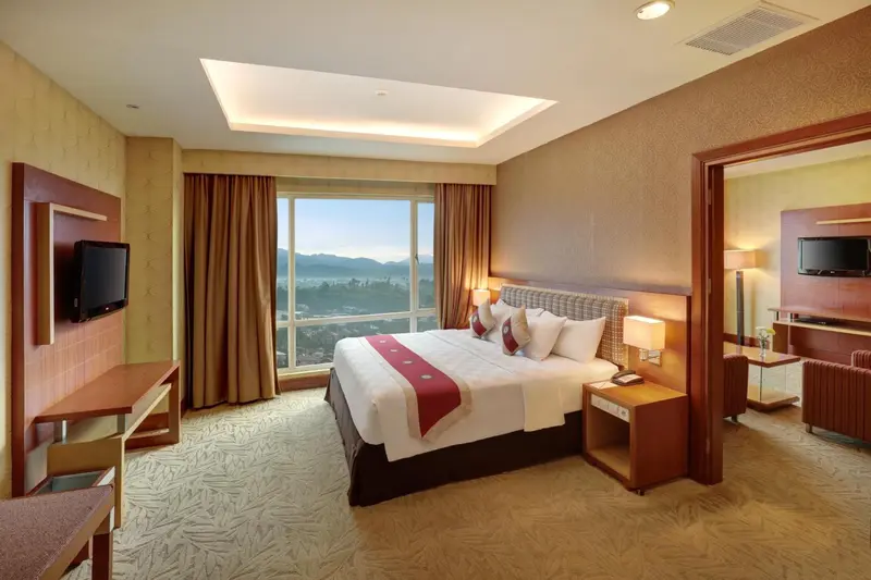 Une chambre d'hôtel lumineuse avec un grand lit et une vue sur la ville.