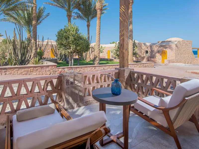 Terrasse aménagée avec mobilier de jardin et vue sur une végétation luxuriante.