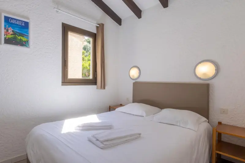 Une chambre lumineuse avec un lit double et des appliques murales.