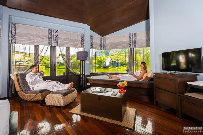 Un couple se relaxe dans un salon lumineux avec vue sur l'eau.