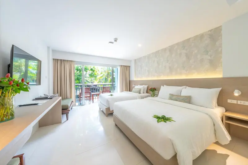 Une chambre lumineuse avec deux lits et un accès à une terrasse.