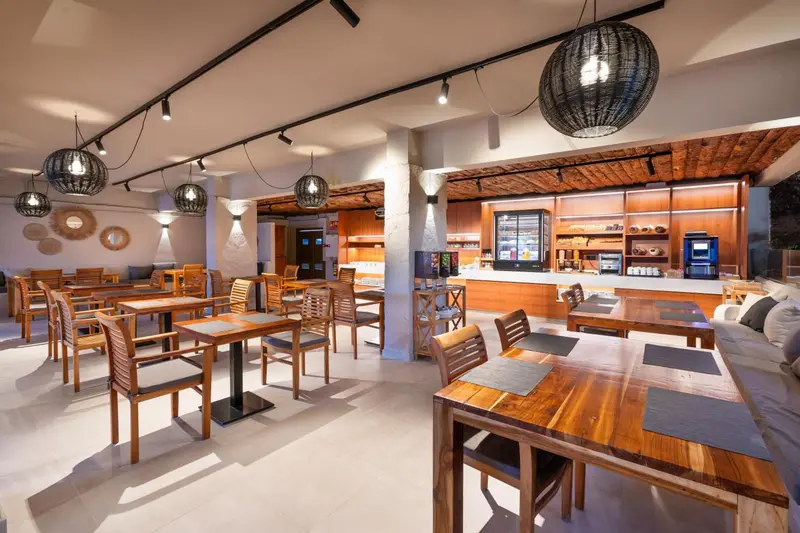 Une salle lumineuse avec des tables en bois et des suspensions décoratives.