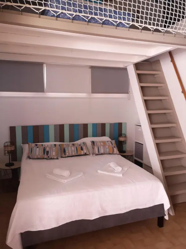 Une chambre lumineuse avec un lit double et une décoration colorée.